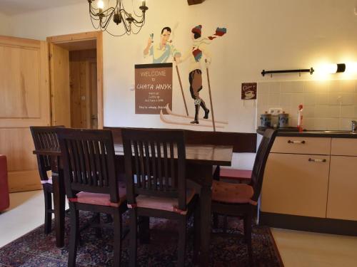 a kitchen with a table with chairs and a sign at Holiday home in a quiet, authentic mountain village with a view of the surrounding hills in Zlatá Olešnice