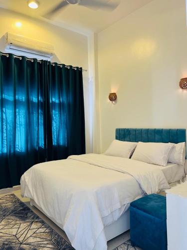een slaapkamer met 2 bedden en een blauw gordijn bij Farah Boutique Private Villa in Luxor