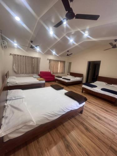 a room with three beds and a ceiling at Glory of MJ, Family Resort in Nature, Panvel in Panvel
