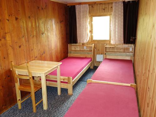 a room with two beds and a table and a window at Agrowczasy Góry Bystrzyckie in Bystrzyca Kłodzka