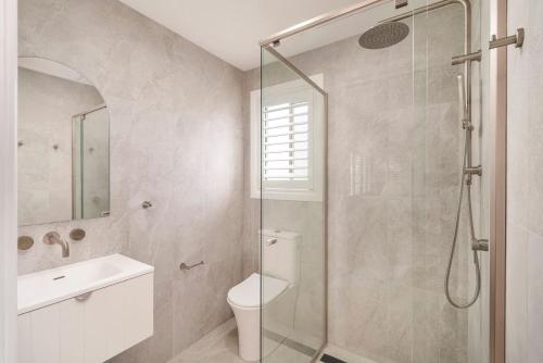 a bathroom with a shower and a toilet and a sink at Dalton Escape in Nelson Bay