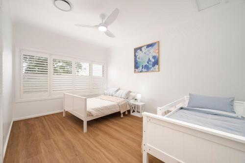 a bedroom with two beds and a window at Dalton Escape in Nelson Bay