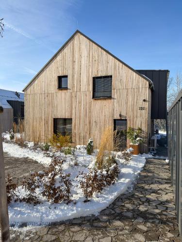 a wooden barn in the snow with a fence at Nora Apartments in Dolní Morava