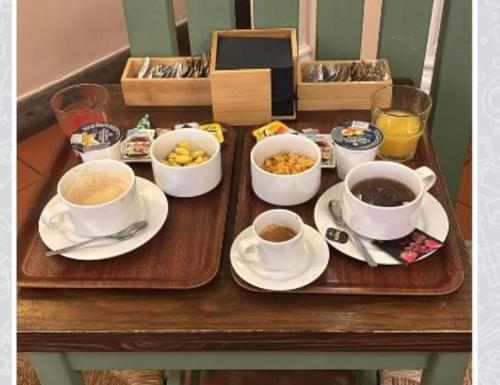 een tafel met kopjes koffie en kommen met eten bij Hotel Panda in Rome