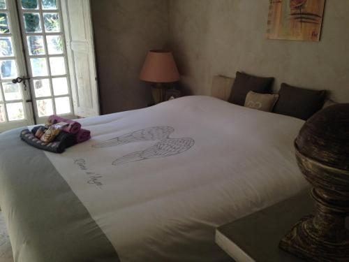 una cama blanca con un dibujo de una persona en ella en La quiétude Provencale, en Trets