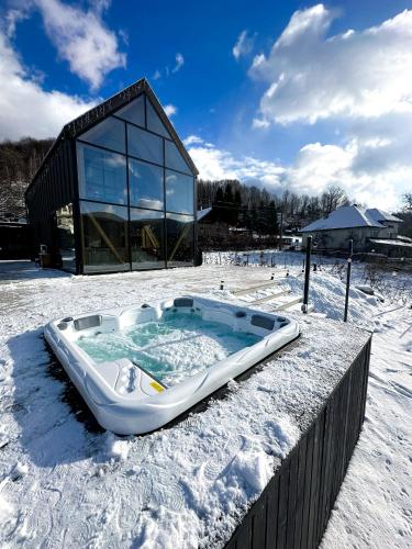 een hot tub in de sneeuw voor een gebouw bij The Hope Firiza in Firiza