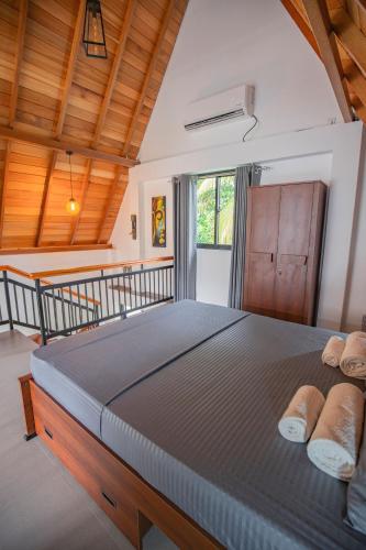 a bedroom with a large bed with wooden ceilings at Gone4Coastal - Cabana in Hikkaduwa