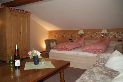 a bedroom with a bed with pink pillows and a table at Alpenchalet Bianca in Ramsau