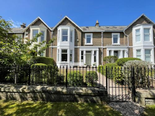 a large house with a wrought iron fence at Castle Beach in Broughty Ferry