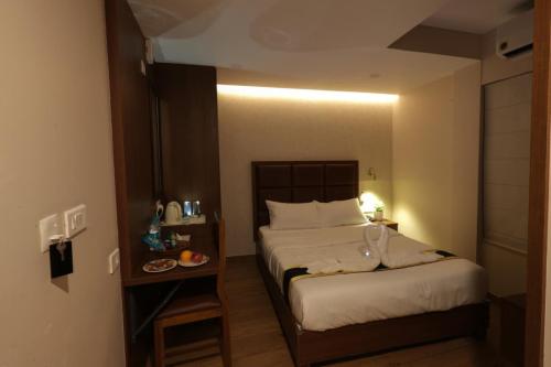 a bedroom with two beds and a table with a plate of food at Fair Stay Hotel in Cochin