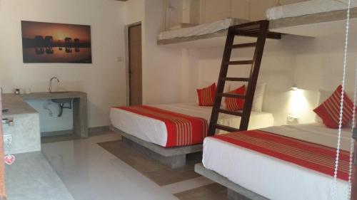 a bedroom with two bunk beds and a bathroom at Kutumbaya in Anuradhapura