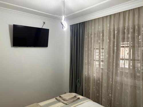 een slaapkamer met een tv aan de muur naast een raam bij Bulevard Residence in Drobeta-Turnu Severin