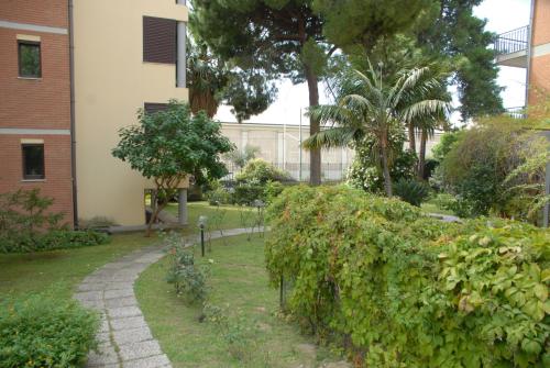 un jardín frente a un edificio con árboles y arbustos en Le Dimore del Sole LT, en Cagliari