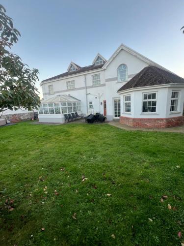 a large white house with a large yard at Family & friends get together birthday hot tub in Porthcawl