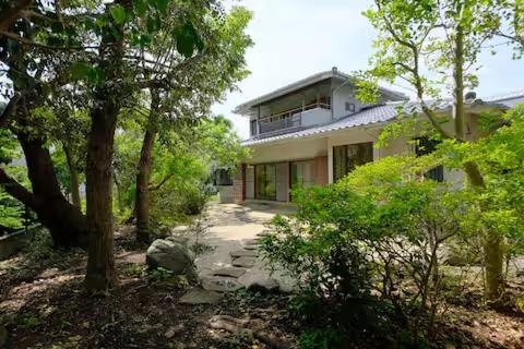a large house with a walkway in front of it at 古民家ゲストハウスときわ in Kamakura