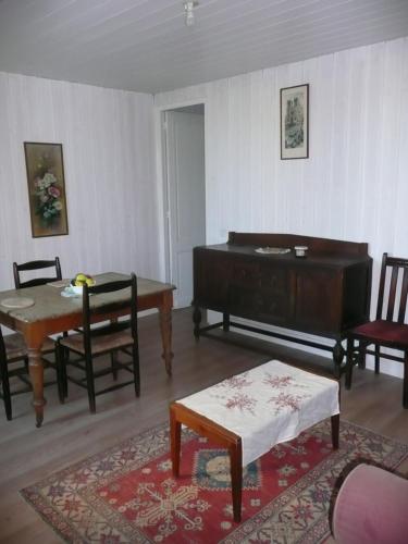 カスティヨン・ラ・バタイユにあるMaison de Vinのリビングルーム(ピアノ、テーブル、椅子付)