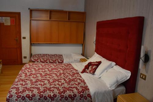 a bedroom with a large bed with a red headboard at Albergo Sella - Monte Amiata in Abbadia San Salvatore