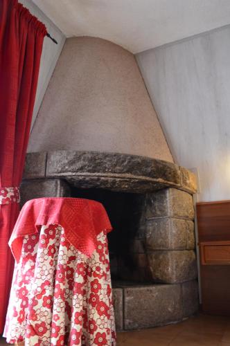 a red and white dress is next to a stone oven at Albergo Sella - Monte Amiata in Abbadia San Salvatore