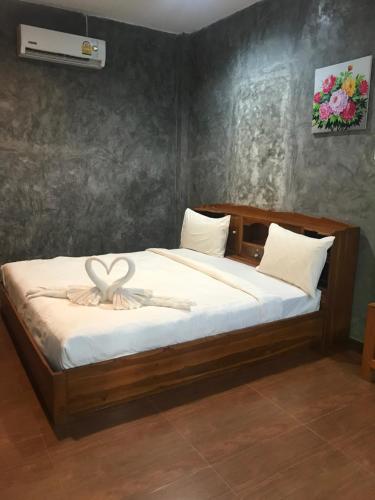 a bed with a wooden frame with a bow on it at MP Resort Koh Phayam in Ko Phayam