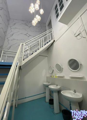 a bathroom with two sinks and a staircase with two toilets at Happy Home Hostel 1 in Vientiane