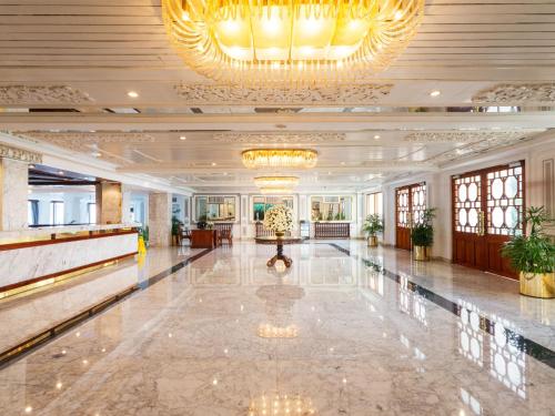 a large lobby with a large chandelier and a marble floor at Mount Lavinia Beach Hotel in Mount Lavinia