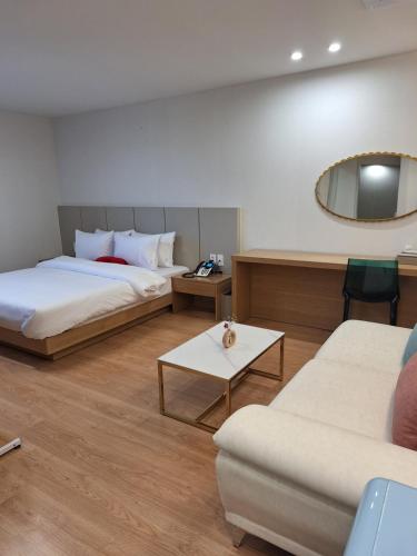 una camera d'albergo con due letti e uno specchio di 마산 쉬자호텔 a Masan