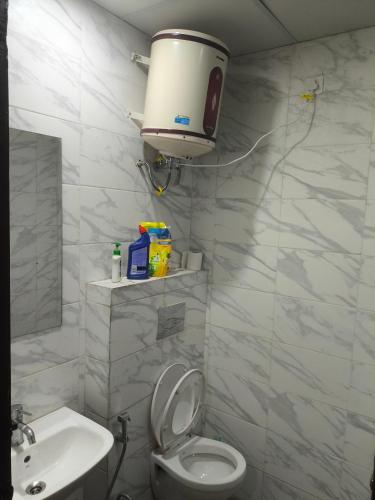a white bathroom with a toilet and a sink at Chandigarh city centre in Zirakpur