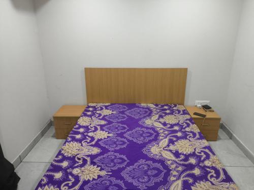 a bed in a room with a purple blanket at Chandigarh city centre in Zirakpur