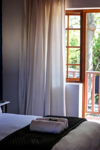 a bed with two towels on it in front of a window at Palm La Vie in Worcester