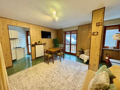 un soggiorno con un tavolo e una cucina di Accogliente appartamento a due minuti dal centro a Limone Piemonte