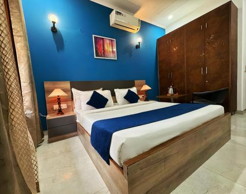 una camera da letto con un letto grande con una parete blu di Haven Hotel Sector 31,Gurugram a Gurgaon