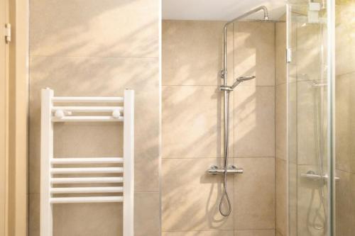 twee foto's van een douche met een glazen deur bij Wave 21 Nida Self Check-In Apartment in Nida