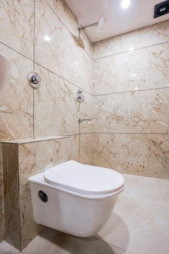 a bathroom with a white toilet and a shower at Hotel Crystal By Glitz Hotels in Mumbai