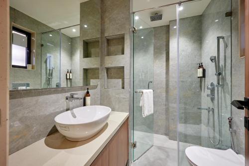 a bathroom with a sink and a glass shower at Hotel Karl Residency in Mumbai