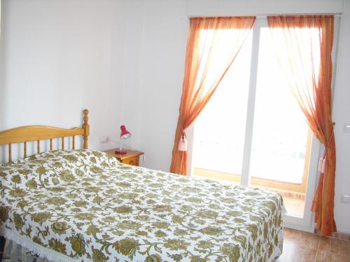 um quarto com uma cama e uma grande janela em Los Miradores Del Puerto - 5207 em La Manga del Mar Menor