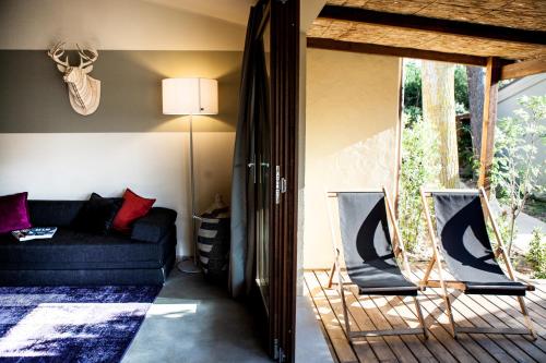 a living room with a couch and two chairs at Camping Village Rocchette in Castiglione della Pescaia