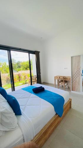 a large bed in a room with a large window at Evara Hill Homestay in Uluwatu