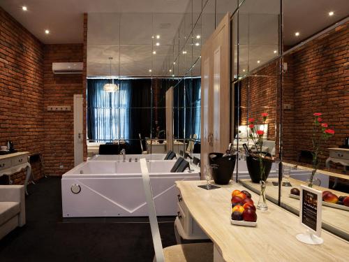 a bathroom with a large tub and a large mirror at Hotel Betmanowska Main Square Residence Adults Only in Kraków