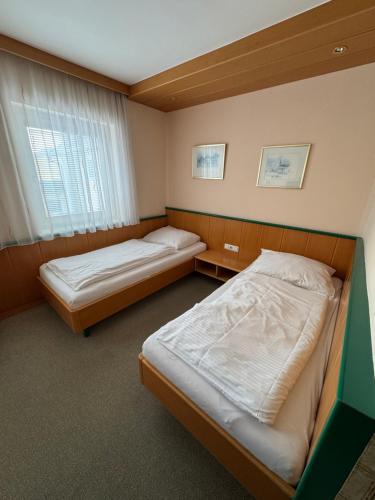 una camera da letto con due letti e una finestra di Gästehaus Stögmüller ad Asten