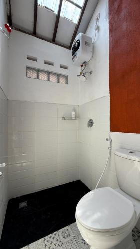 a bathroom with a white toilet in a room at ŚamaStay in Yogyakarta