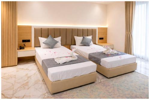 twee bedden in een hotelkamer met twee bedstanden bij Hotel Premium Rudram Atithi Niwas Varanasi, Near Kashi Vishwanath Temple And Ganga Ghat- Fully Air conditioned & Spacious Room - Prime Location Book It Early in Varanasi