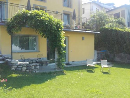 a house with a yard with a table and chairs at Hotel Corte Santa Libera in San Fedele Intelvi