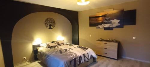 a bedroom with a bed and a dresser at Gîte L'Olivier - Piscine partagée in Lagorce