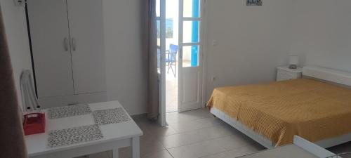 a bedroom with a bed and a door to a balcony at Filina's Studio Corner in Maltezana