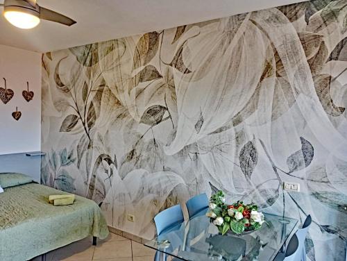 a bedroom with a floral mural on the wall at Monolocale Tre Mari in Capoliveri