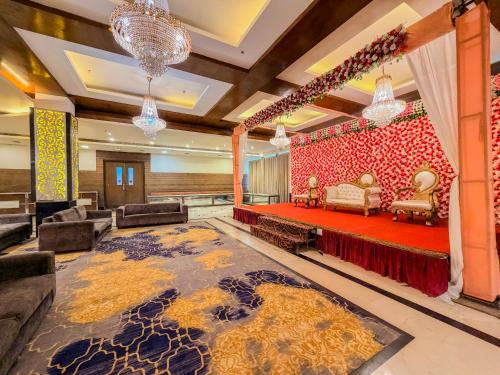 a lobby with a red couch and chairs and a rug at Spree Hotel Meerut in Meerut