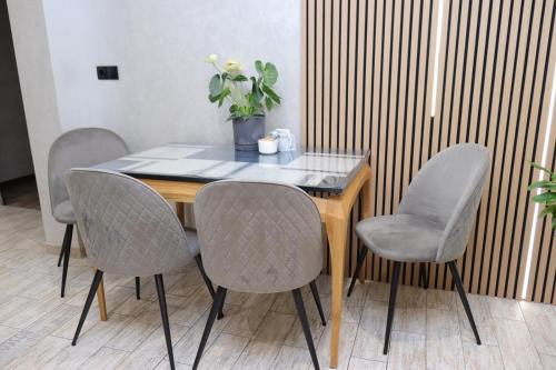 a table with four chairs and a vase with a plant at Садиба "Hutsulyana" in Dobrovelychkivka
