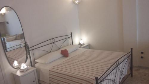 Dormitorio pequeño con cama con espejo en Dimora Polimnia, en Polignano a Mare