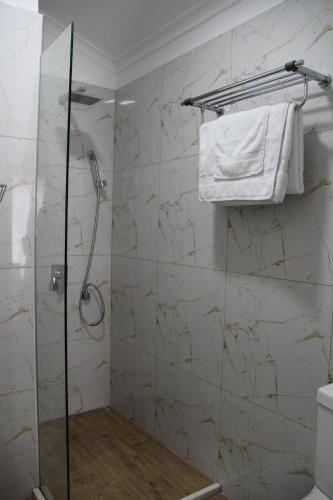 a bathroom with a shower with a glass door at Hotel Hermes Tirana in Tirana