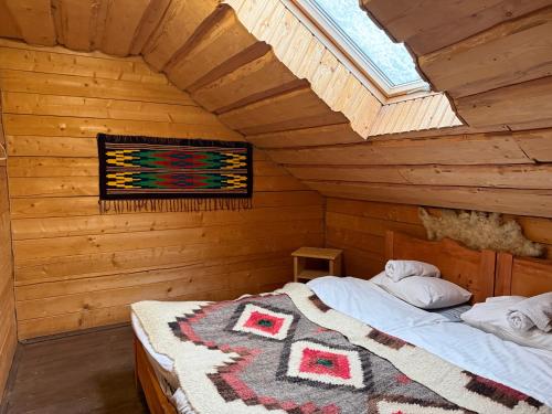 una camera da letto con un letto in una cabina di legno di Guesthouse Karpaty a Yasinia